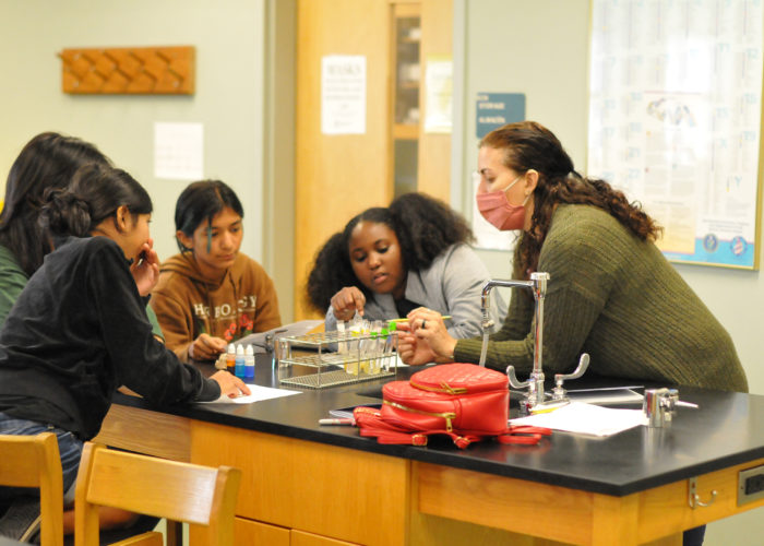 Teacher addressing small group of students at work table, Credit: Central Carolina Community College (CCCC)