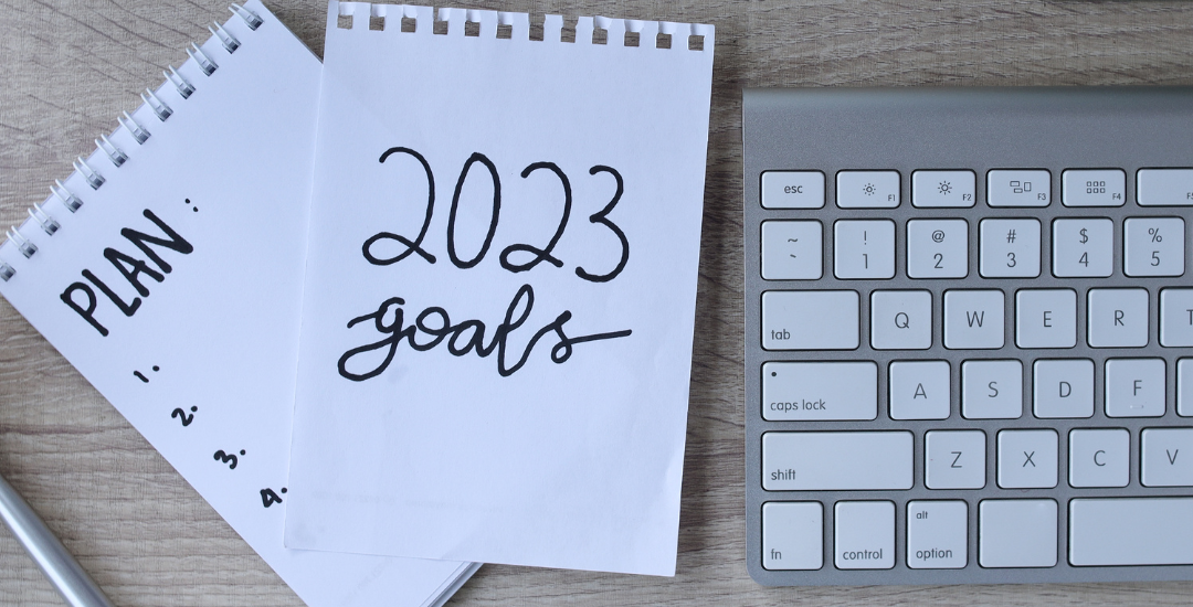 a list that says 2023 goals by a computer and a pair of glasses