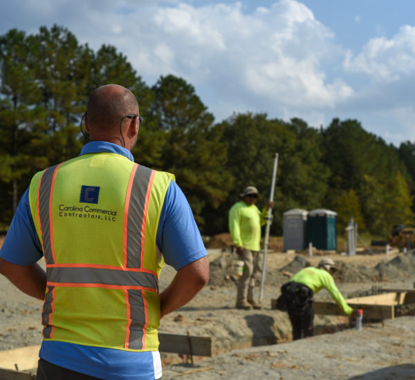 Person in construction vest overviewing workers. Credit: Carolina Commercial Contractors