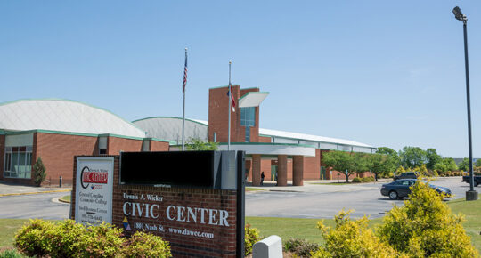 civic center. a large brick building resting on a parking lot