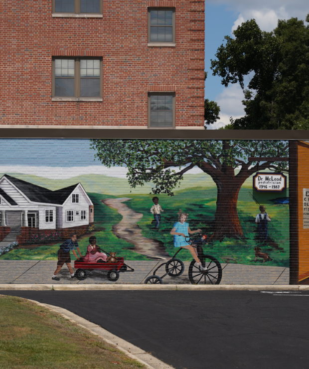 A mural of a house and children playing in the front yard. Credit: Ahmod Goins