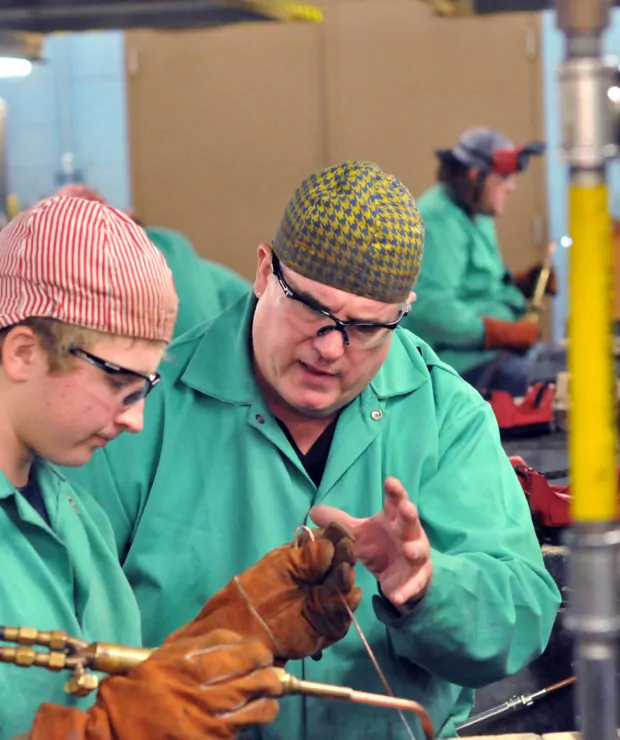 Teacher guides student in manufacturing construction equiptment. Credit: Central Carolina Community College (CCCC)