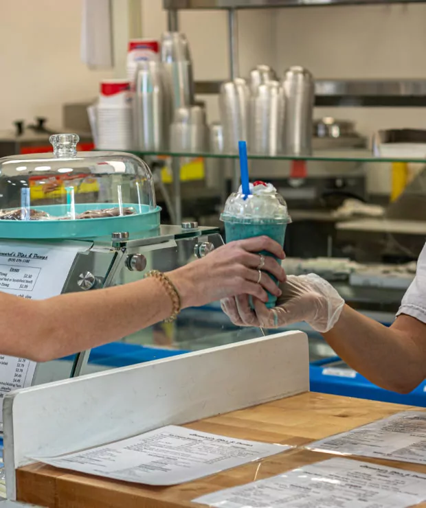 Employee hands milkshake to customer. Credit: Ahmod Goins