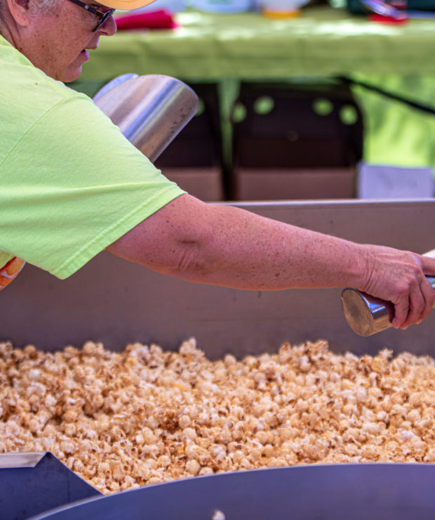 Person seasoning a large batch of popcorn. Credit: Ahmod Goins