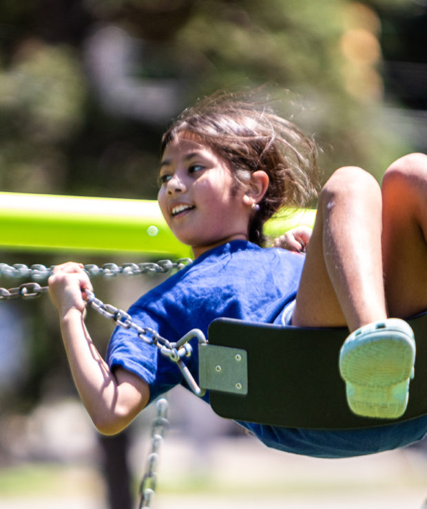 Child sits on swing at park. Credit: Ahmod Goins