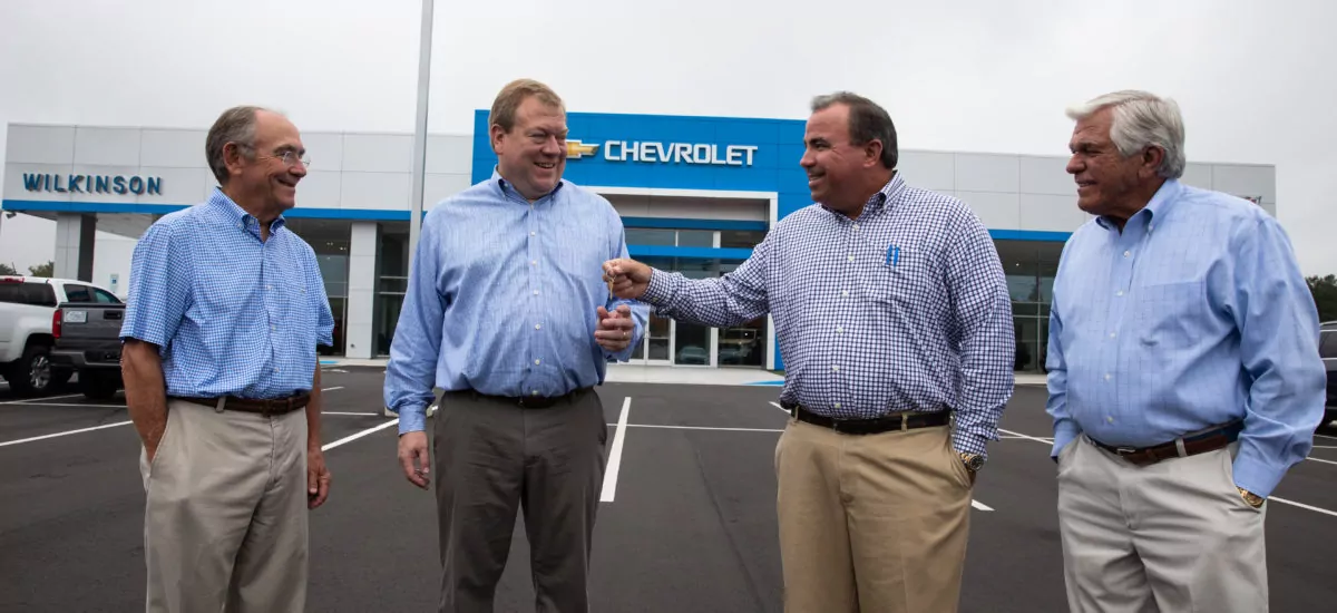 Four men outside Chevrolet dealership. Credit: Carolina Commercial Contractors